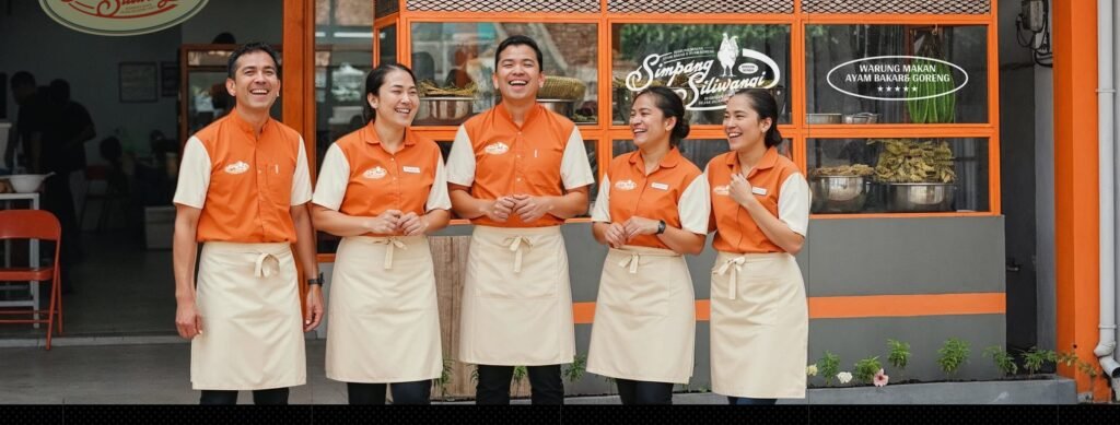 Ayam Simpang Siliwangi staff in orange uniforms in front of the restaurant